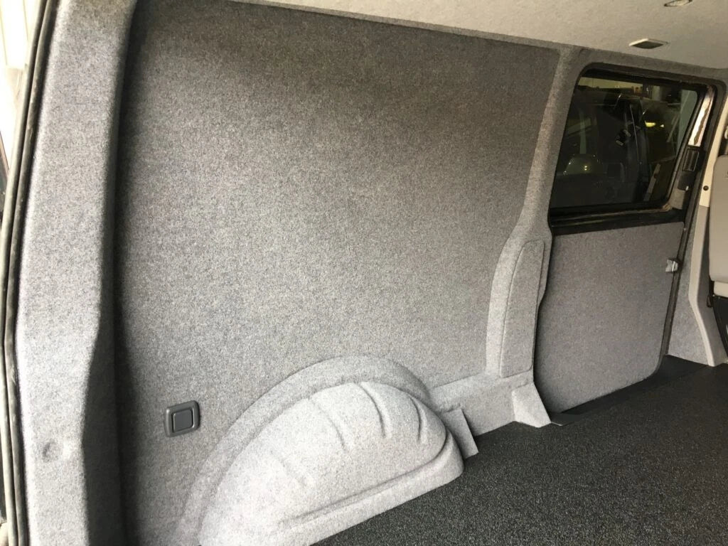 Grey lining carpet fitted around a van side panel and wheel arch