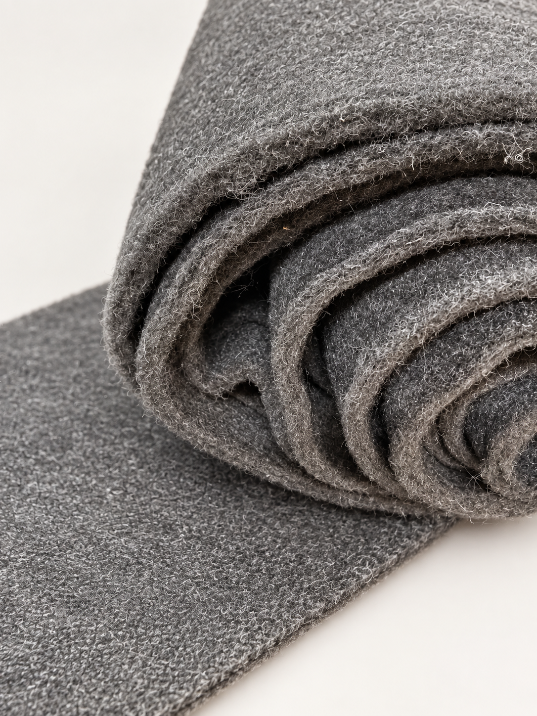Studio-enhanced view of charcoal 4mm carpet lining rolled with its sheet face visible
