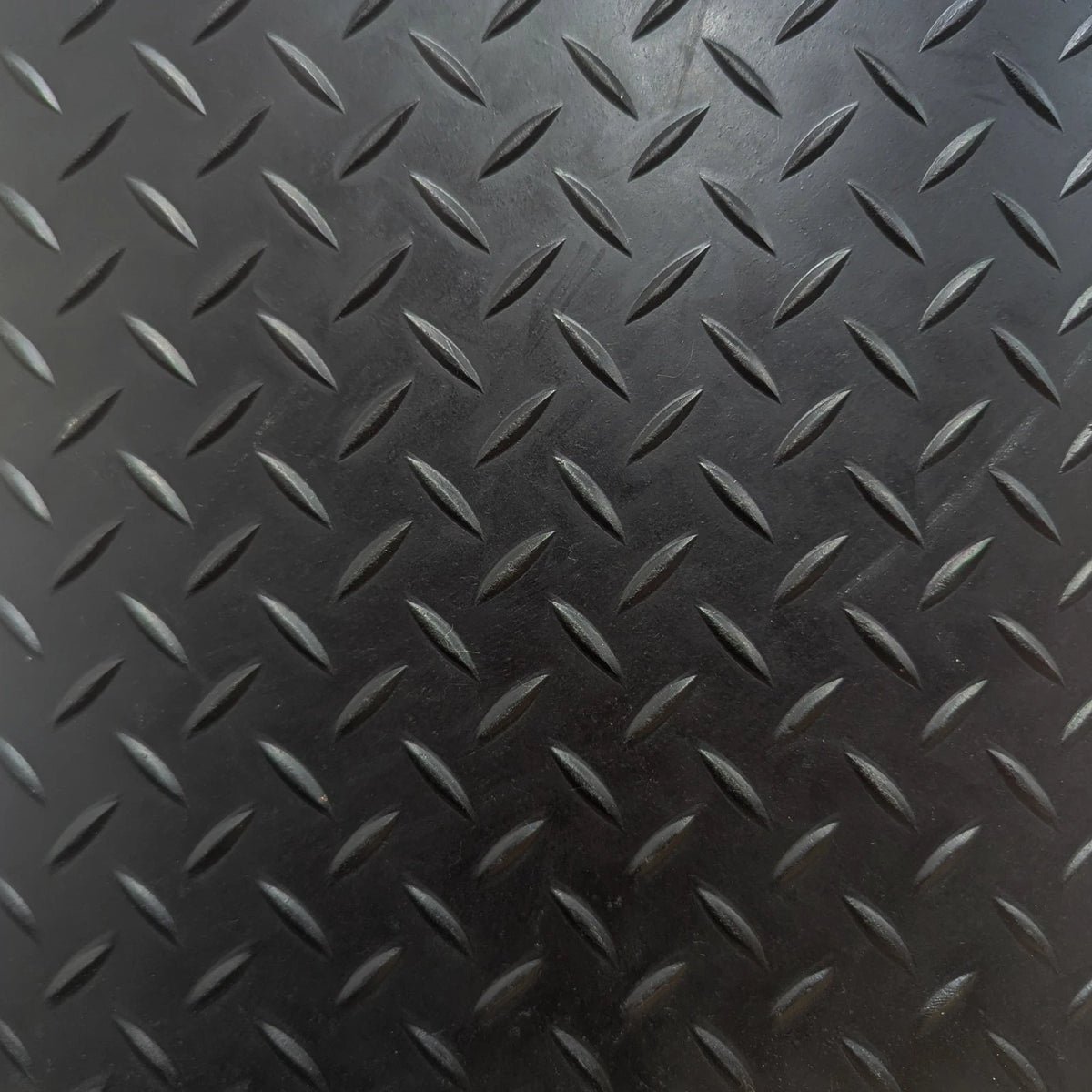Close-up of black chequer plate rubber flooring tread