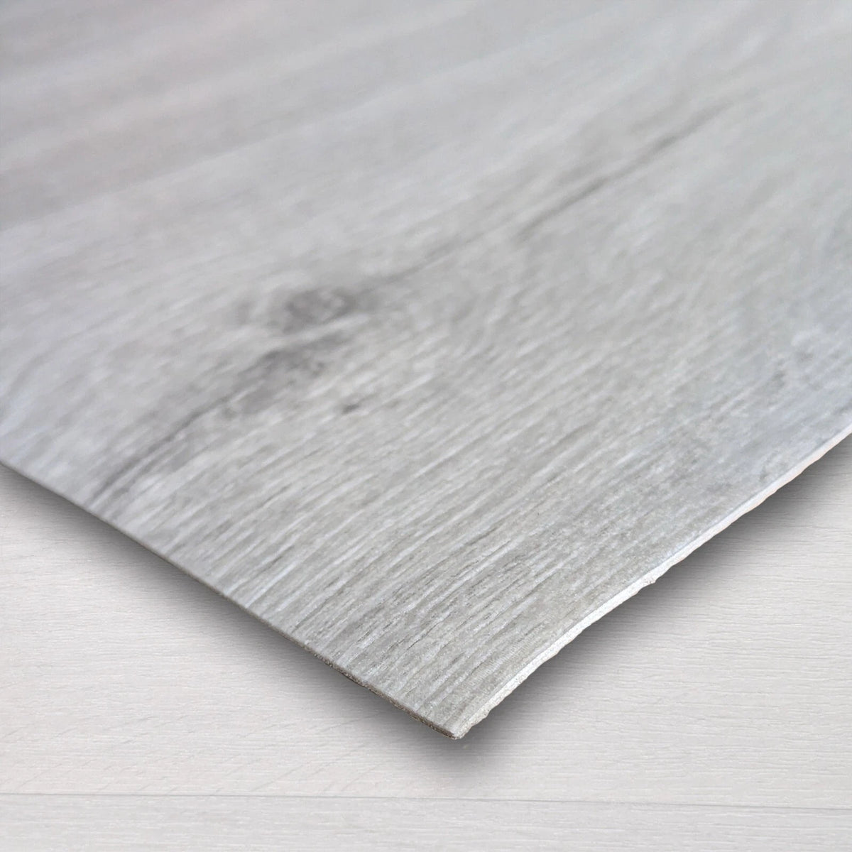 Close-up of a light grey wood-effect vinyl sheet edge and grain pattern