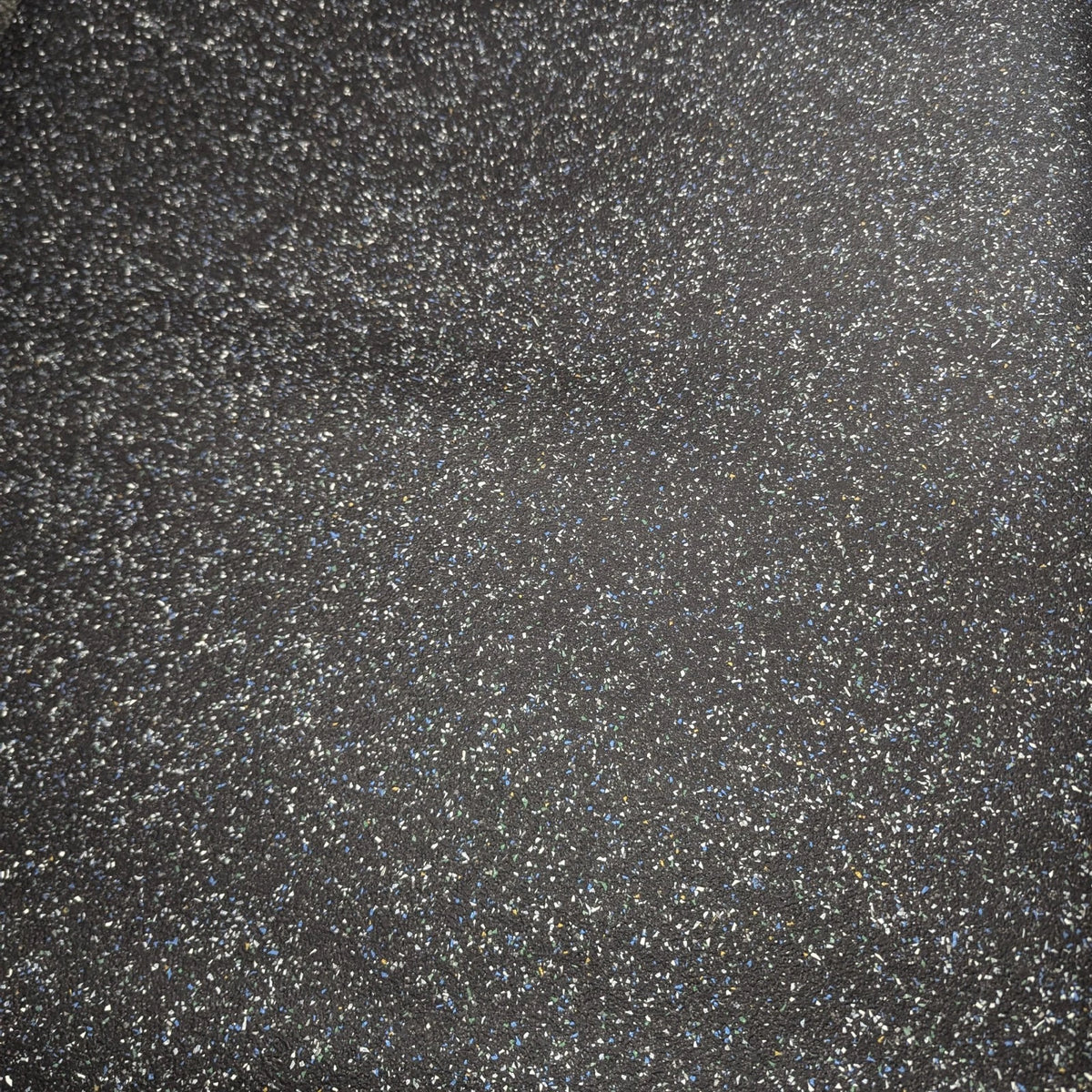 Black speckled vinyl flooring surface viewed from above