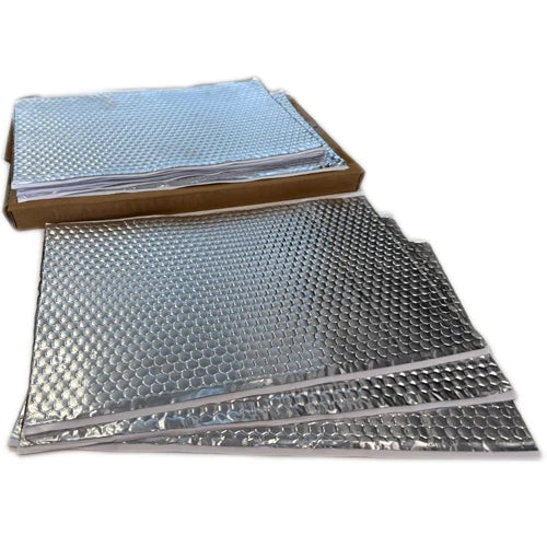 Sound deadening sheets stacked in a cardboard tray with loose sheets laid in front