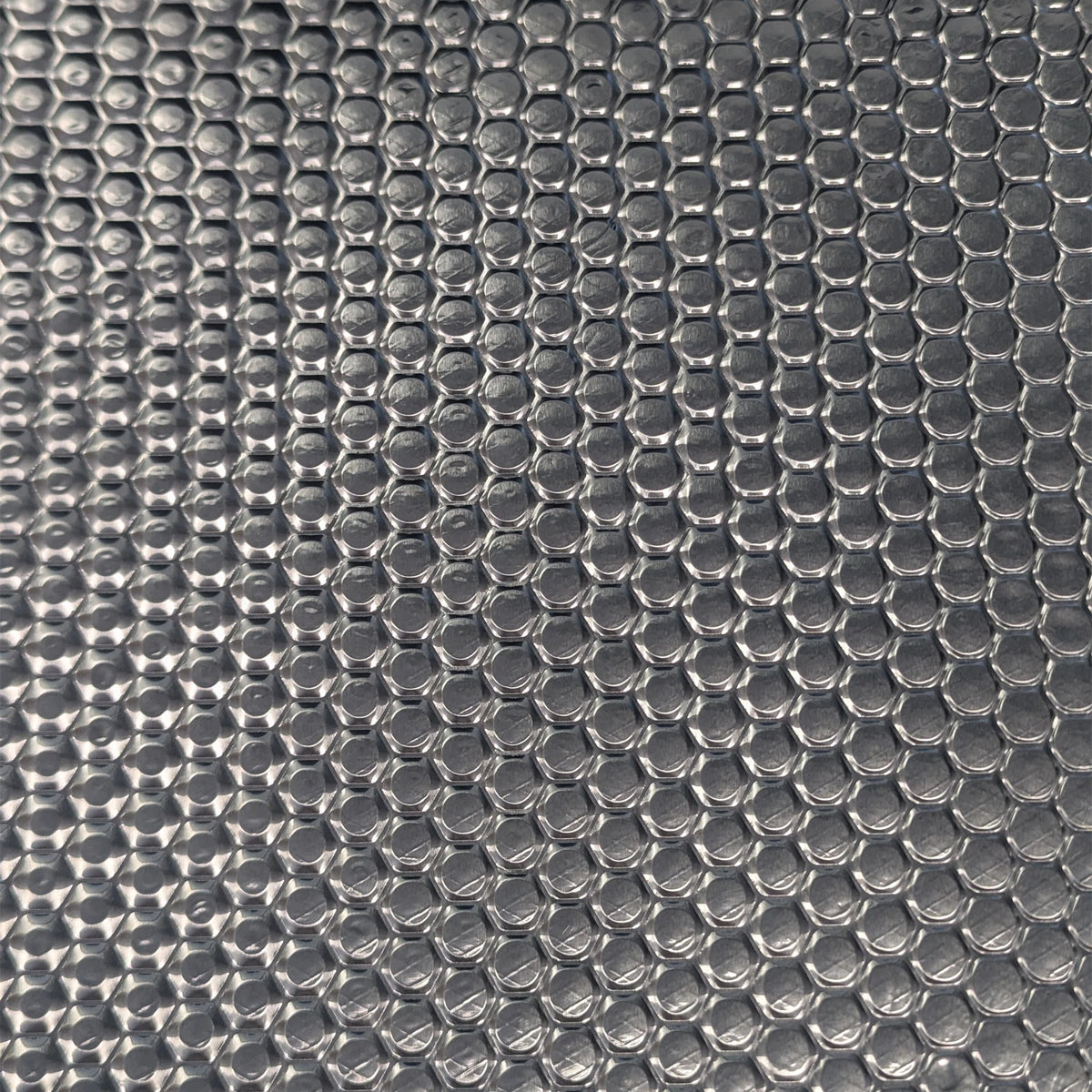 Close-up of the embossed foil surface across a sound deadening sheet